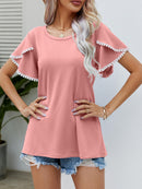 T-shirt à col rond et manches flottantes avec bordure à pompons