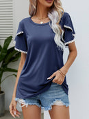 T-shirt à col rond et manches flottantes avec bordure à pompons